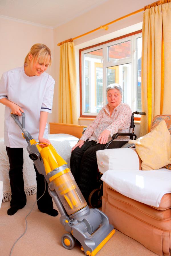 caregiver vacuuming room